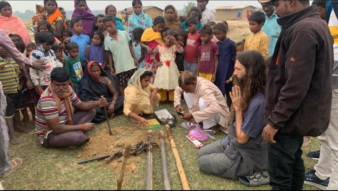 Michael sitting in prayer with the Bihar community at the well blessing